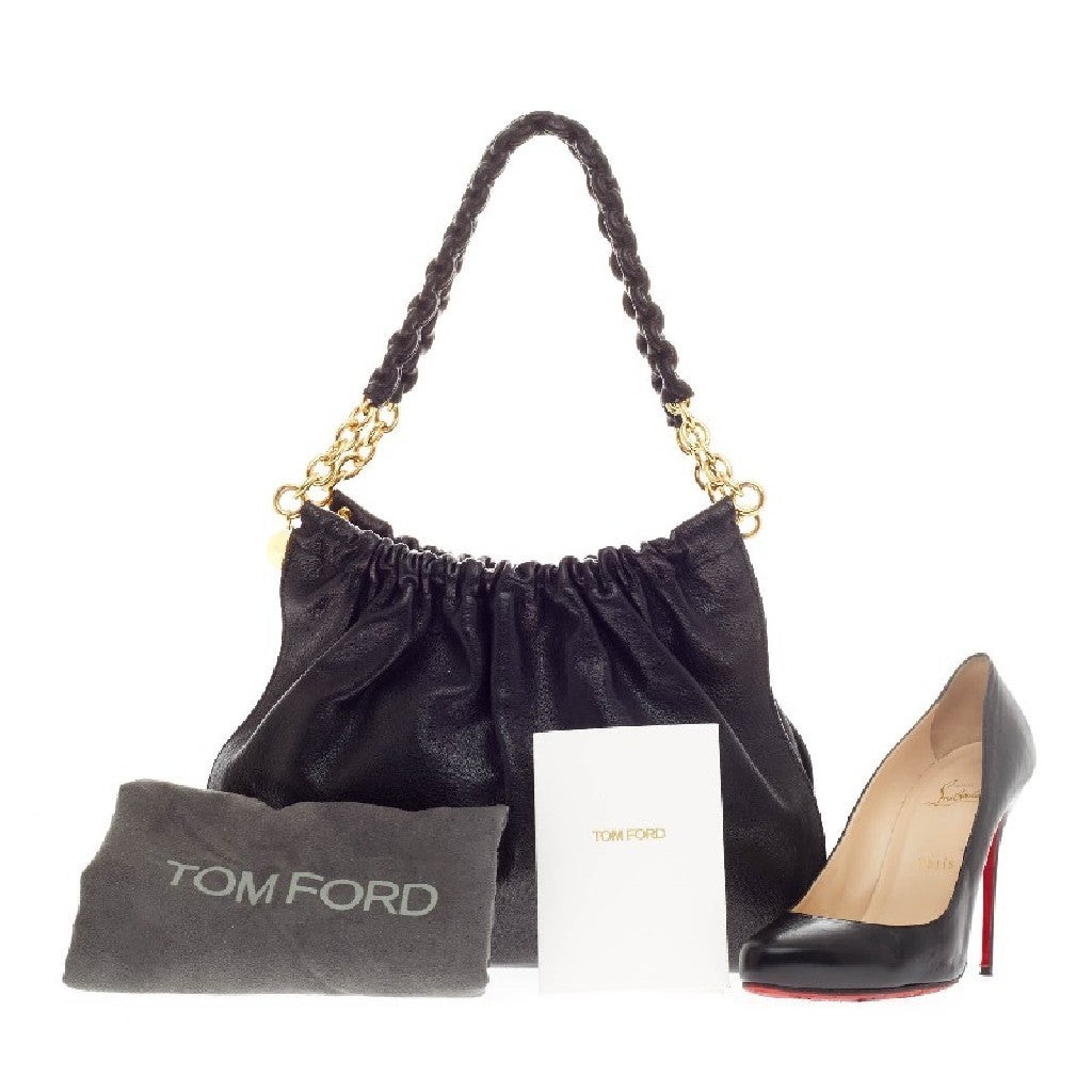 This authentic Tom Ford Wrapped Chain Handle Bag Leather is every fashionista’s dream. Constructed from soft black leather with a ruched pleated design, this sleek yet feminine bag features wrapped leather chain shoulder straps with gold hardware.