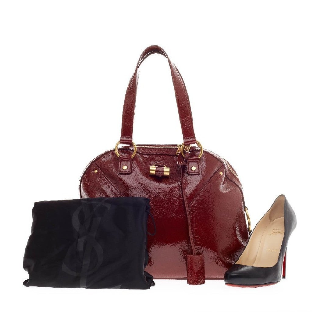 This authentic Saint Laurent Muse Shoulder Bag Patent Large in dark red patent is beautiful and elegant. Its roomy size and gracious shape makes this authentic bag an absolute must-have. It is quite versatile and can be styled with any dressed down