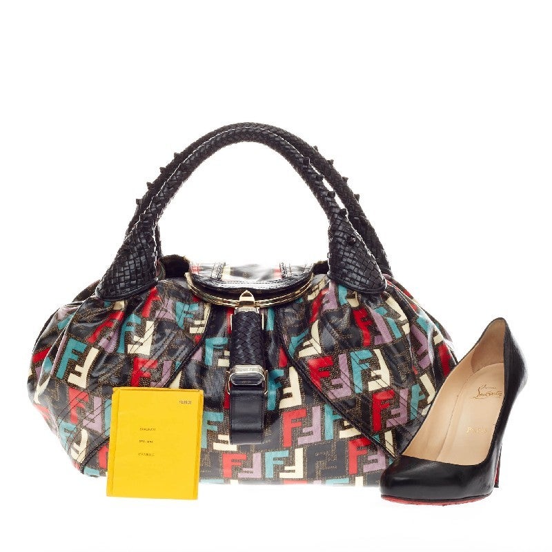 This authentic Fendi Spy Bag Multicolor Coated Zucca in eye-catching coated Multicolor Zucca print is a kitschy and fun reinterpretation of the classic Fendi Spy Bag. It features the unmistakeable spiked leather woven handles and a secret silver