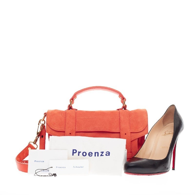 This authentic Proenza Schouler PS1 Satchel Suede Tiny is the ideal way to travel with style and functionality. Constructed in bright orange brushed suede, this miniature satchel is accented with brass-tone hardware and features a detachable