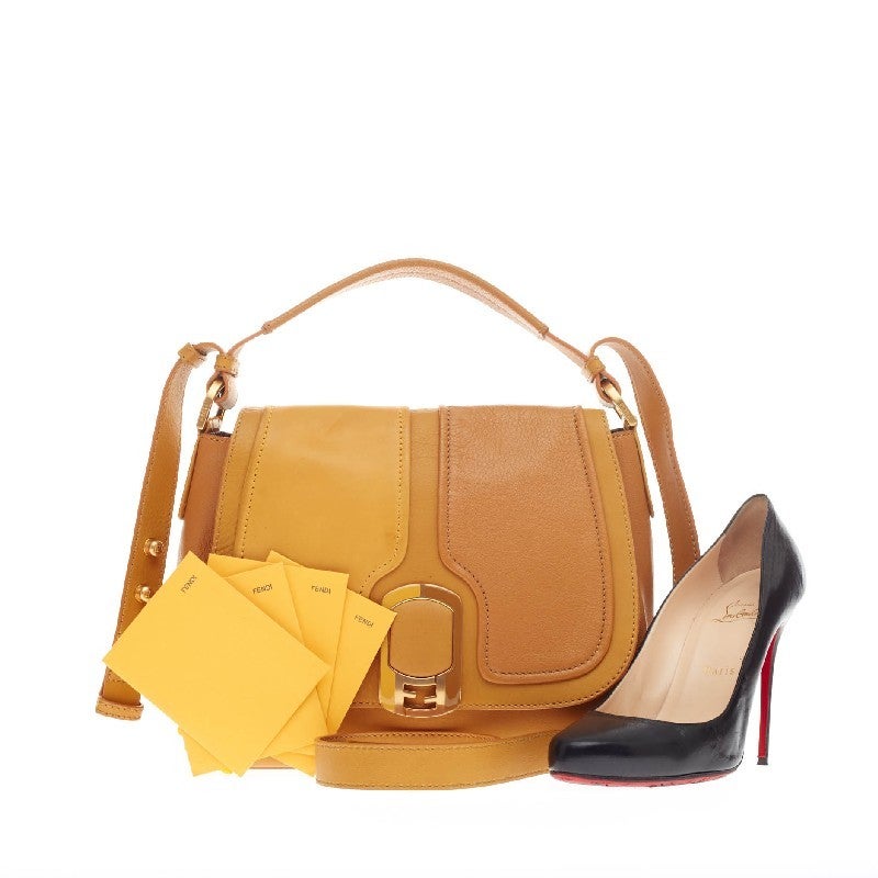 This authentic Fendi Anna Flap Bag Leather in color-blocked tan and mustard yellow neutrals showcases a classic style with a 70's flair. Constructed in pebbled leather panels, stylish top handle features an adjustable strap, protective base studs,