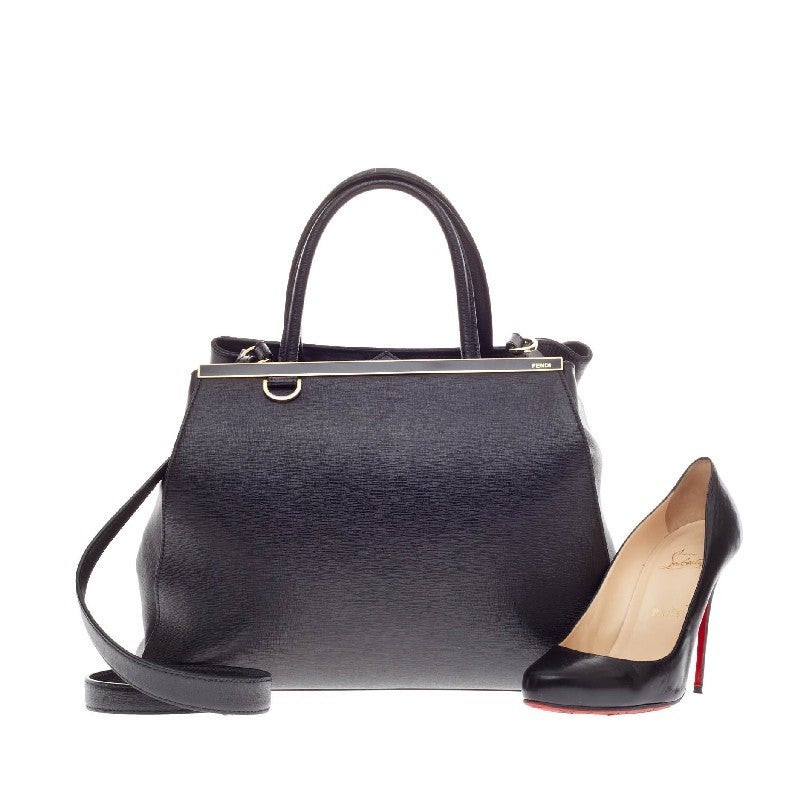 This authentic Fendi 2Jours Leather Medium is impeccably stylish with its sleek black hue, simple silhouette and finely crafted in sturdy cross-grain leather and soft calfskin sides. It is accented with a shining top bar that dons the Fendi brand