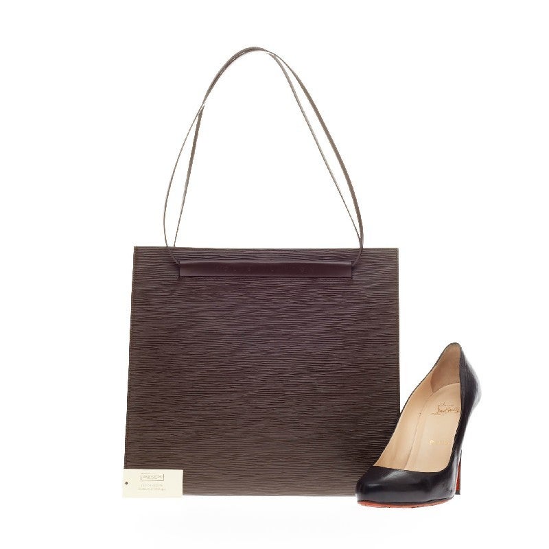 This authentic Louis Vuitton Saint Tropez Epi Leather is constructed from Louis Vuitton's notable Epi leather. This slender purse, in moka dark brown features a silver snap magnetic closure for easy accessibility and long shoulder straps that fit