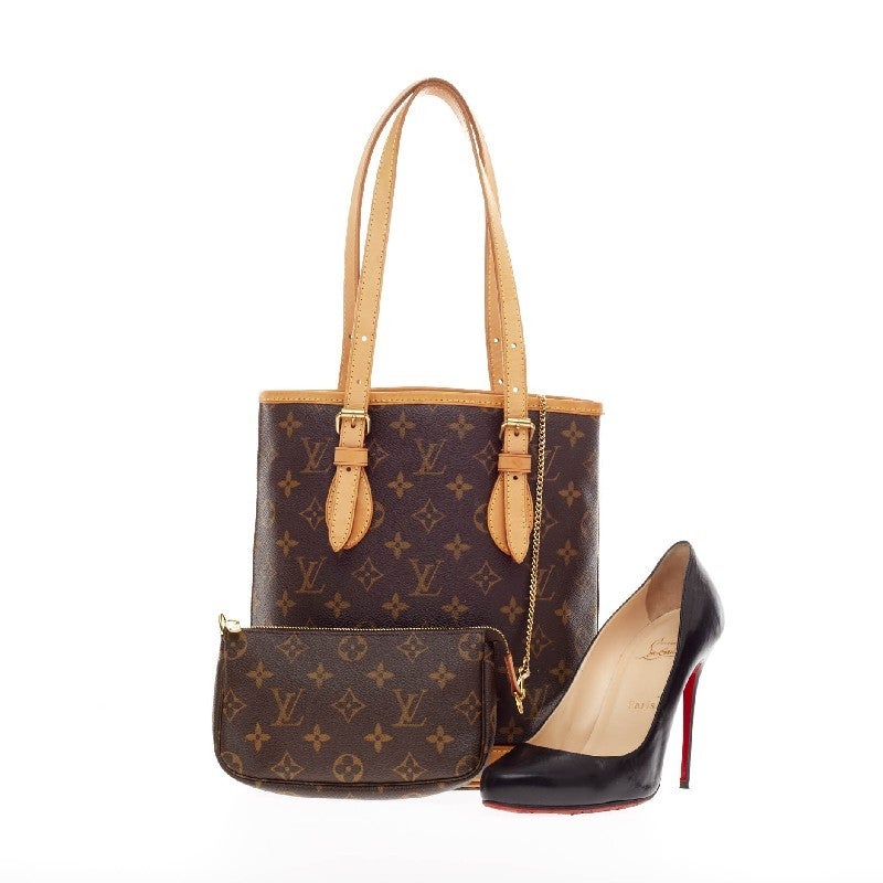 This authentic Louis Vuitton Petit Bucket Bag Monogram Canvas features the brand's timeless monogram print. The oval base of the bag is structured and trimmed with natural cowhide leather that keeps the bag free-standing and features adjustable belt
