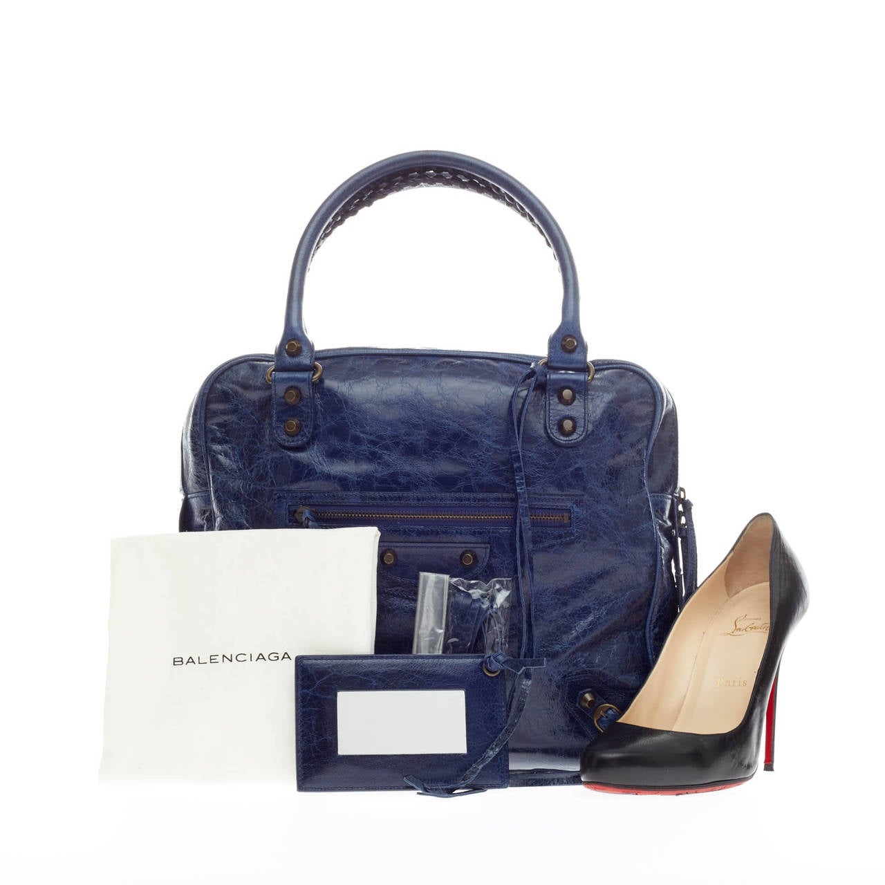 This authentic Balenciaga Mini Bowling Classic Studs Leather debuting in 2006 is miniature in size but bold in style. Constructed in vivid blue roi navy leather, this bowling bag features a flat square silhouette, signature braided top handles, long