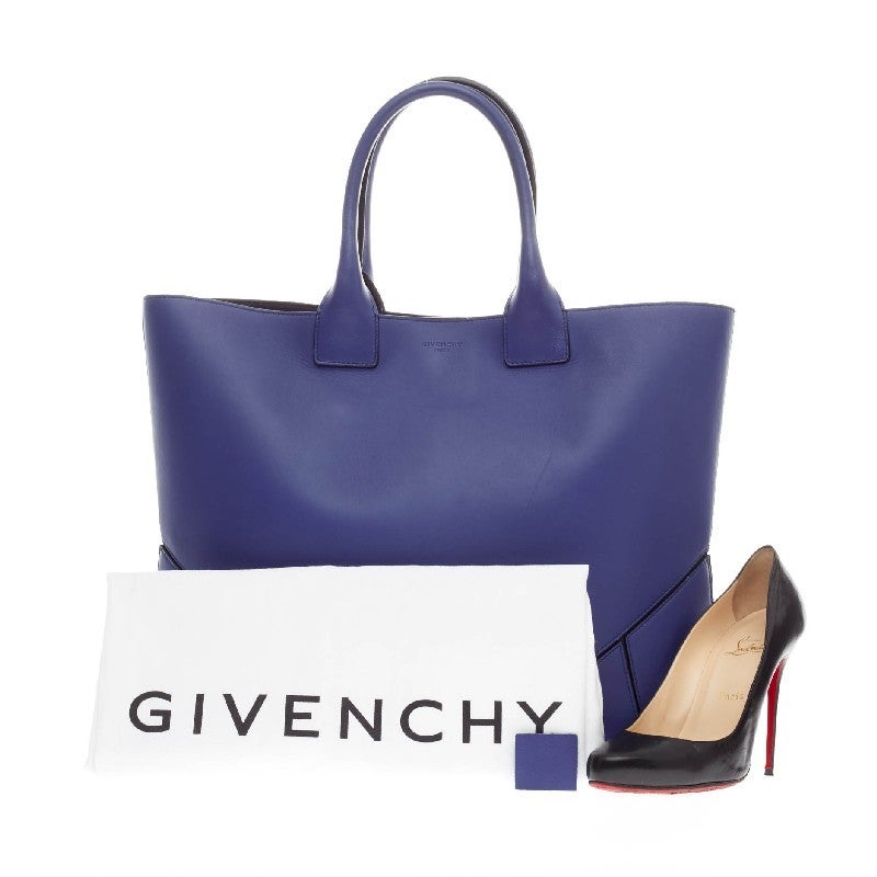 This authentic Givenchy Easy Tote Leather Medium in bright blue lambskin is a simple, and stylish tote perfect for daily excursions. This sleek, minimalist style tote features dual-rolled handles, geometric-paneled base and silver magnetic snap