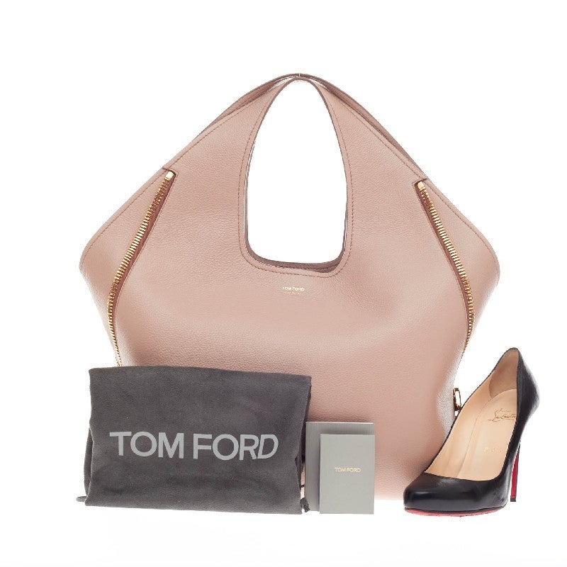This authentic Tom Ford Jennifer Hobo Calfskin redefines modern luxury with timeless elegance. Crafted in blush nude pebbled calfskin leather, this minimalist oversized hobo features broad looping leather shoulder straps, base studs, gold-tone