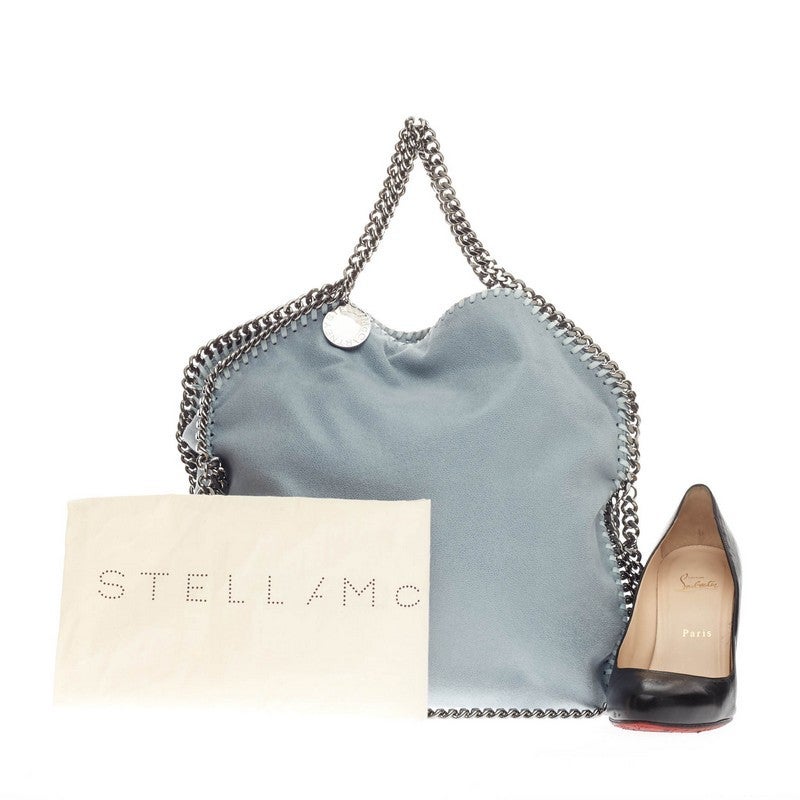 This authentic Stella McCartney Falabella Fold Over Shaggy Deer is perfectly textured with pale blue falabella shaggy deer polyester. This no-fuss, easy tote features gunmetal chain link handles and trim, whipstitched edges, and a hanging logo disc.