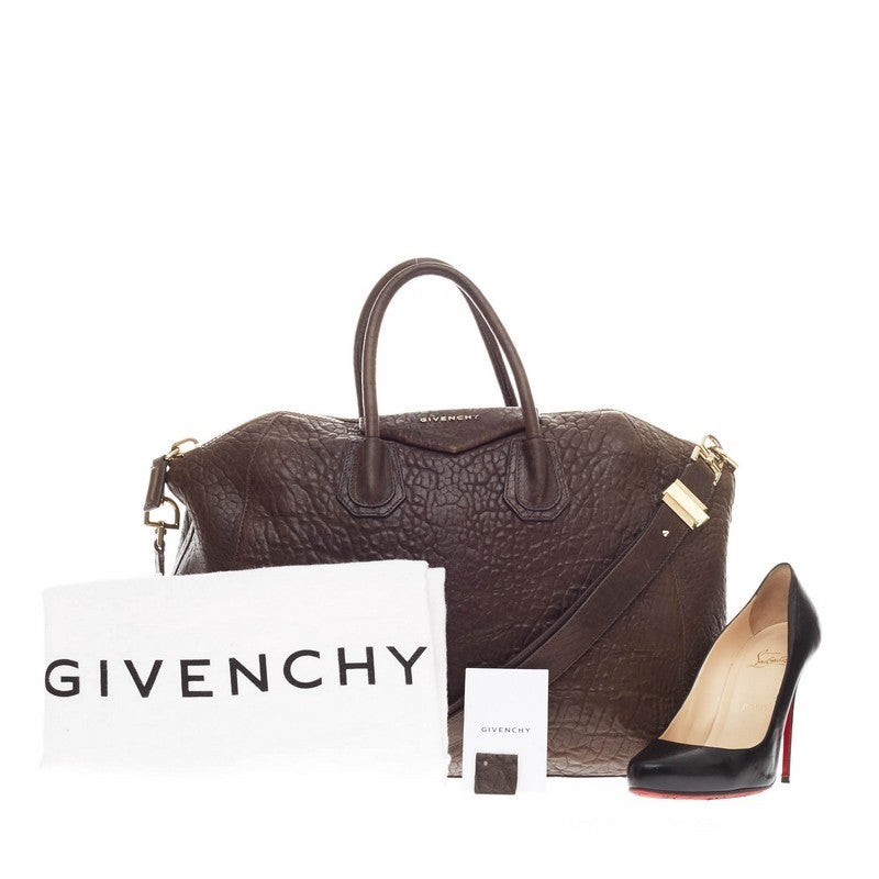 This authentic discontinued Givenchy Antigona Bag Pebbled Leather Large debuting in 2011 combines style and simplicity all-in-one. Crafted from brown pebbled leather, this oversized, slouchy duffle is designed with the brand's signature envelope