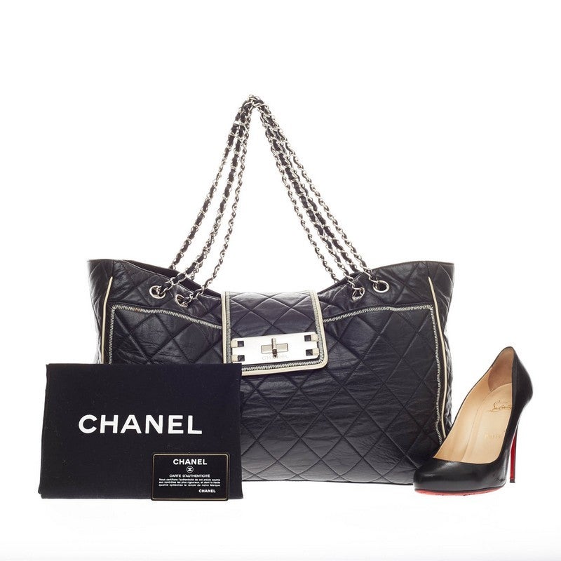 This authentic Chanel Reissue East West Tote Quilted Lambskin Large is an elegant, classic bag that every fashionista needs in her wardrobe. Crafted from black diamond quilted leather with cream trimmings, this oversized tote features four woven-in