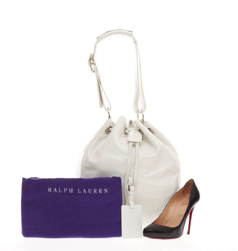 This authentic Ralph Lauren Drawstring Bucket Bag Python is a unique and eye-catching minimalist-style bag perfect for modern fashionistas. Crafted in white genuine python skin, this popular drawstring bucket bag features an adjustable wide shoulder