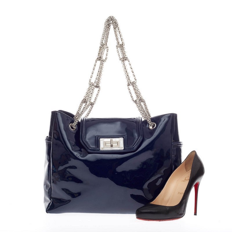 This authentic Chanel Bijoux Chain Mademoiselle Lock Tote Patent combines luxurious style and the brand's elegant design. Crafted in sleek navy blue patent leather, this oversized tote features an oversized top flap mademoiselle lock with an