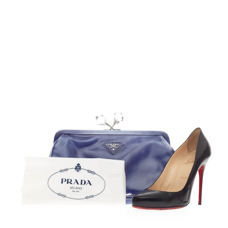 This authentic Prada Kisslock Crystal Clutch Leather is perfect for night outs. Crafted in faded bluette spazzolato calfskin leather, this elegant framed clutch features a plexi diamond-shaped crystal kiss-lock, iconic raised triangle Prada logo and