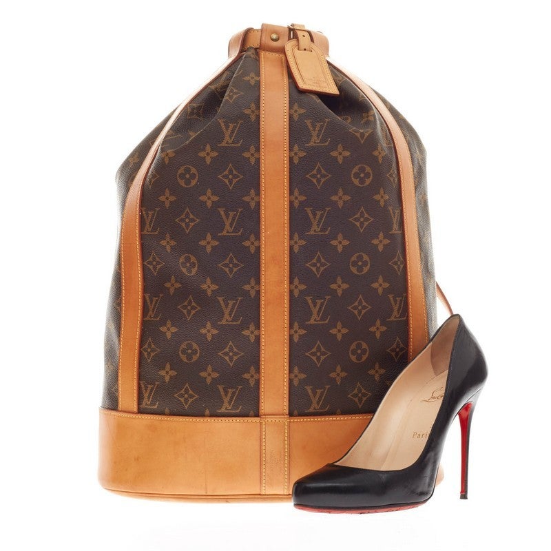 This authentic Louis Vuitton Randonnee Monogram Canvas GM in brown monogram canvas with vachetta leather trimmings combines the functionality of an everyday carry-all and casual luxury all in one. The unique backpack showcases a reinforced base that