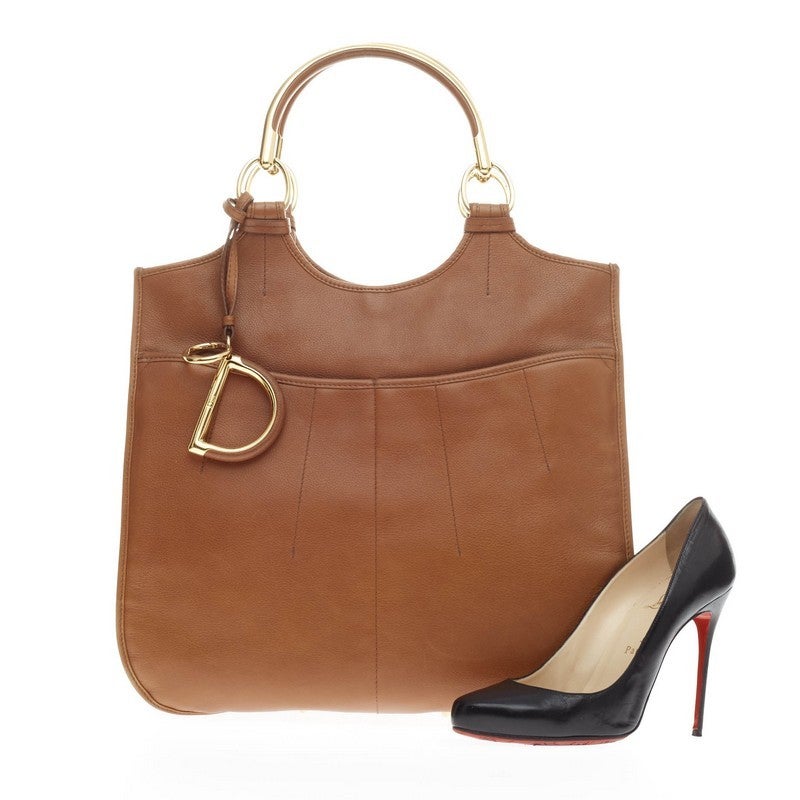 This authentic Christian Dior 61 Tote Leather created in celebration of Dior's 61st anniversary collection is a luxurious yet practical bag for everyday use. Crafted in supple camel leather with detailed stitching, this strikingly simple tote