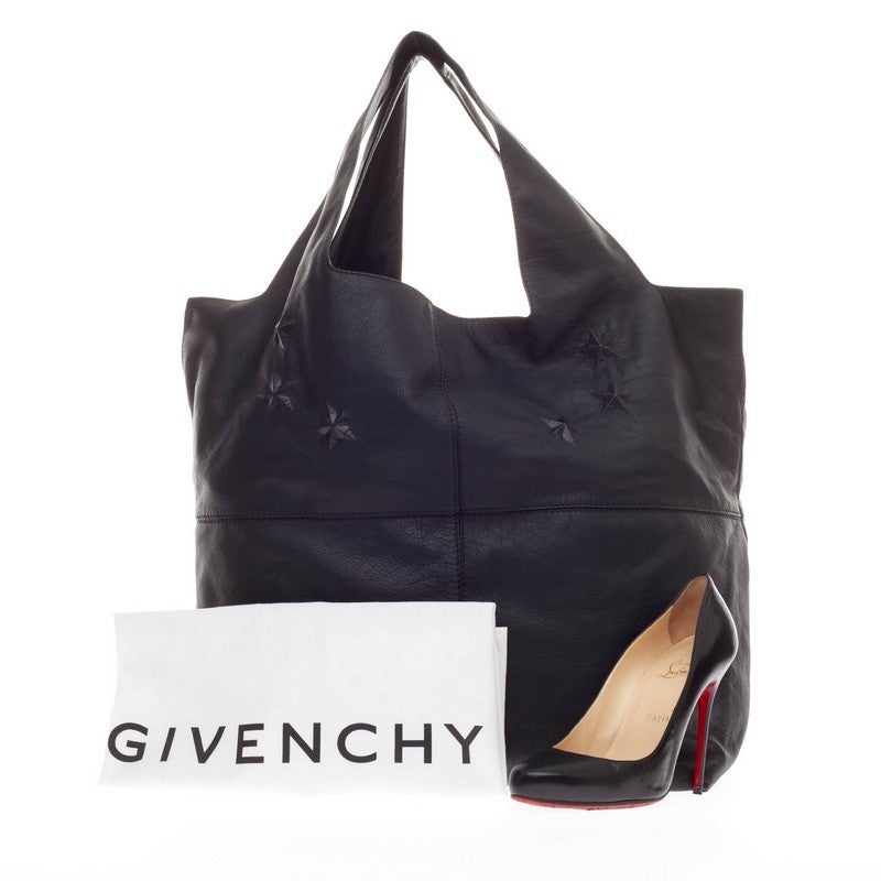 This authentic Givenchy George V Bag Leather mixes the brand's sleek aesthetic with an edgy touch perfect for daily excursions. Crafted in supple black leather, this simple apron-style tote features subtle six raised star detailing at its center, a