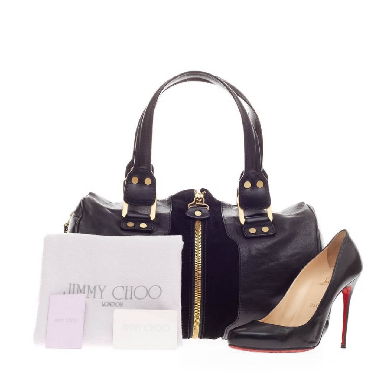 This authentic Jimmy Choo Marla Bag Leather is your stylish everyday bag. Crafted in black leather with suede center panels, this simple yet edgy bag features dual-rolled handles, a center zip closure that adjusts for expansion, side zip pockets and