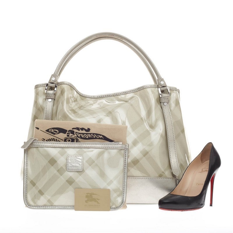 This authentic Burberry Double Layered Tote PVC Nova Check Canvas is perfect for casual wear. Crafted in glossy PVC in the brand's signature nova check print with metallic silver leather trims, this bag features dual-rolled handles, protective base