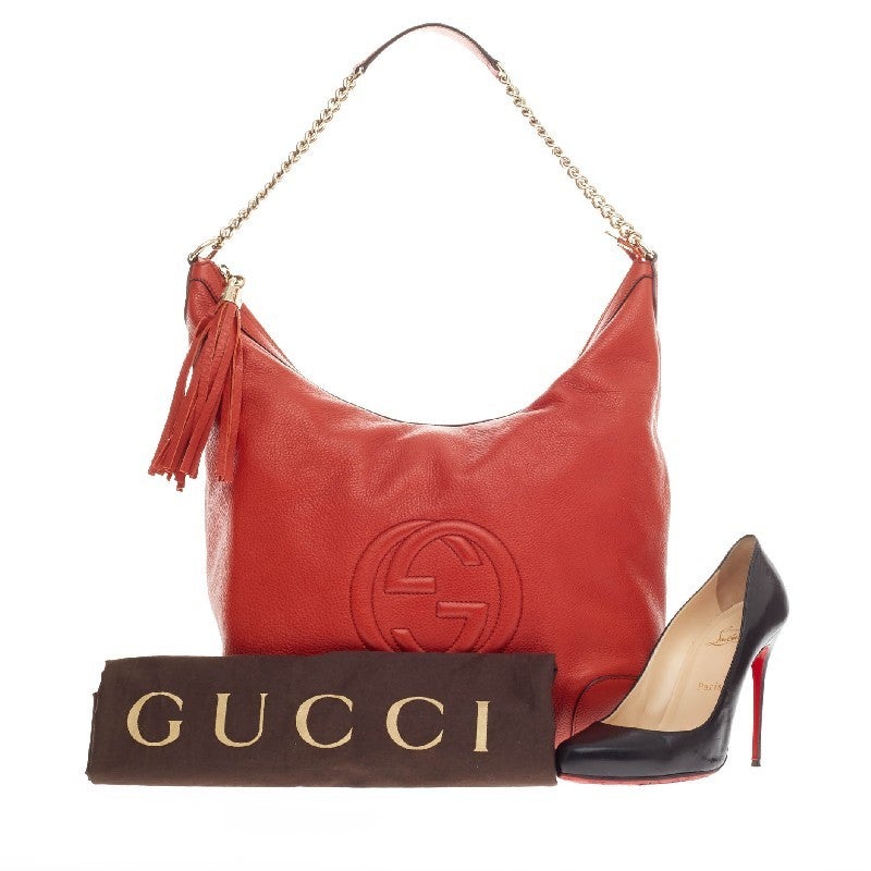 This authentic Gucci Soho Hobo Chain Strap Leather Medium is simple yet stylish in design. Crafted in burnt orange pebbled leather, this hobo features gold chain straps with leather pads, fringe tassel, and signature interlocking Gucci logo stitched