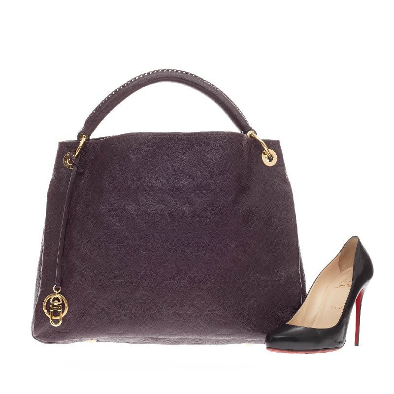 This authentic Louis Vuitton Artsy Monogram Empreinte Leather MM is as elegant as it is sturdy. Crafted in beautiful Aube purple embossed leather with subtle LV monogram imprints, this luxurious and refined hobo features a single looped braided top