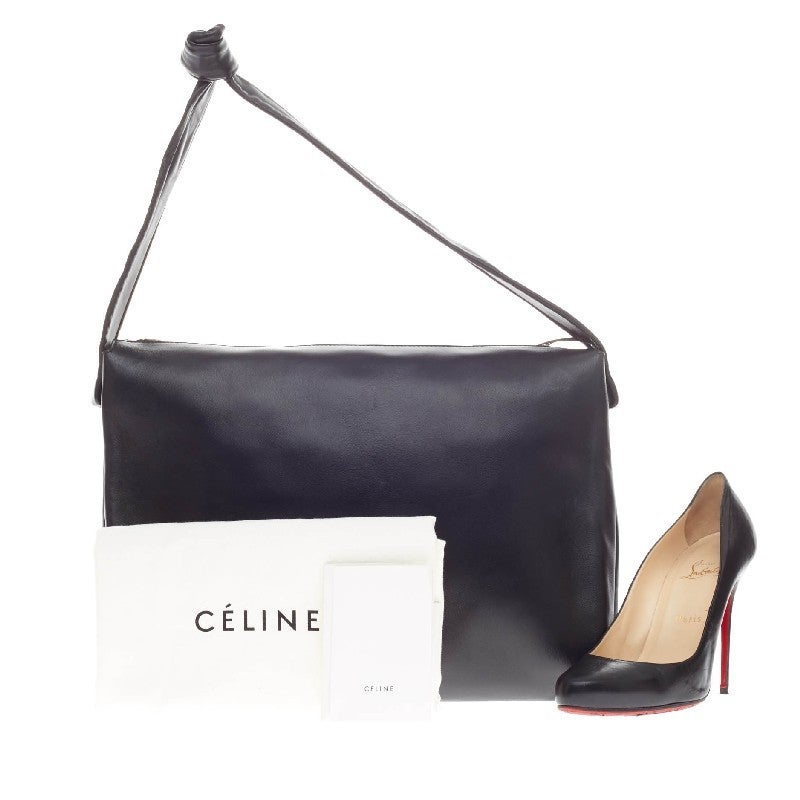This authentic Celine Knotted Bag Leather constructed in beautiful black leather and silver-tone hardware, is one of the most sought-after designs from Celine. The unique knotted handle, compliment the bag's classic  and minimalist design. Its top
