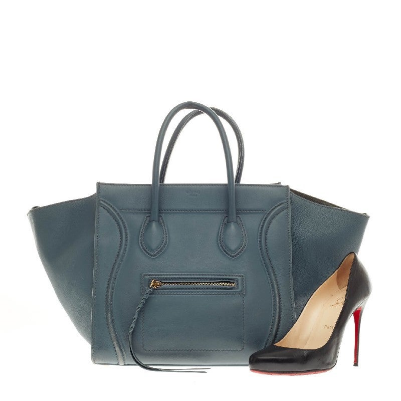 This authentic Celine Phantom Smooth Leather Medium is one of the most sought-after bags beloved by fashionistas. Crafted from smooth blue-grey leather, this oversized minimalist tote features a braided zipper pull, gold-tone zipped front pocket,