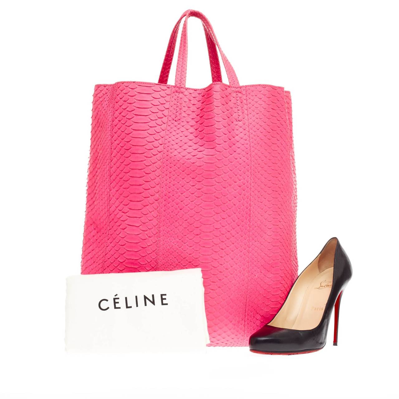 This authentic Celine Vertical Cabas Tote Python Large  balances a simple yet luxurious style perfect for an on-the-go woman. Crafted in beautiful fluo pink genuine python skin, this minimalist shopper features slim handles and a gold stamped Celine