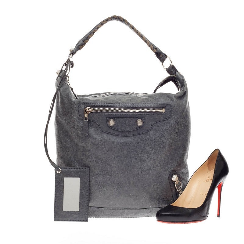 This authentic Balenciaga Day Hobo Giant Studs Leather in gris tarmac gray distressed leather is a go-to essential that fits everyday essentials. This spacious hobo is accented with an intertwined braided leather top handle, front exterior zip