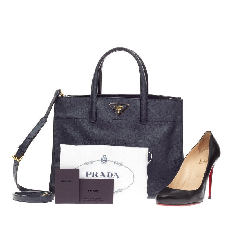 This authentic Prada Soft Triple Pocket Tote Saffiano Leather is elegant in its simplicity and structure. Crafted in stunning Baltico navy blue saffiano leather, this stylish yet functional tote features dual-top handles, protective base studs,