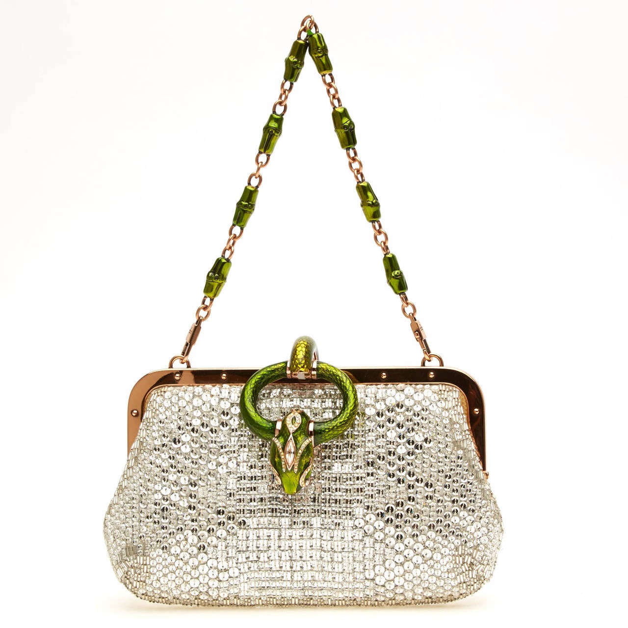 This stunning Gucci Crystal Evening Snake Head Clutch is decked with vibrant silver sequins. The rose gold hardware trimming is accented with a green metallic snake head encrusted with crystals securing the frontal flap and a matching beaded handle.