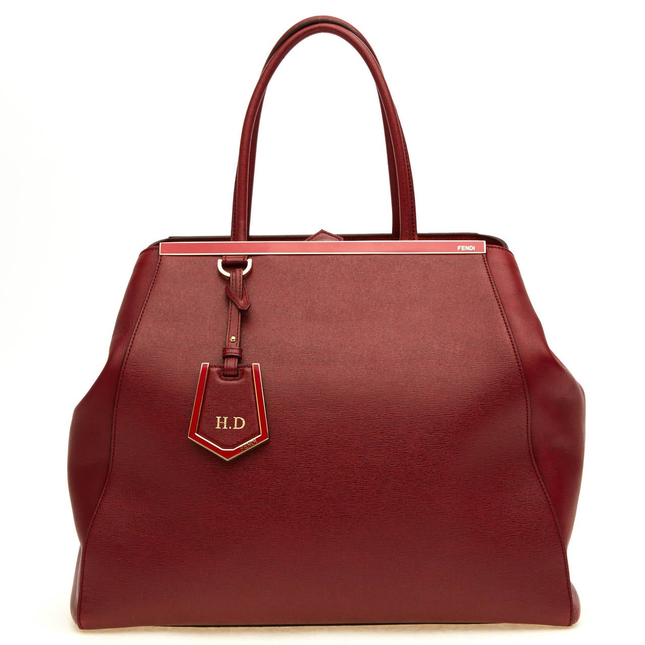 This refined Fendi Leather 2Jours in Large is featured in a soft brick red hue, and is perfect for the fall and winter. It is accented with a shining top bar that dons the Fendi brand name. It is also equipped with protective metal feet. This item