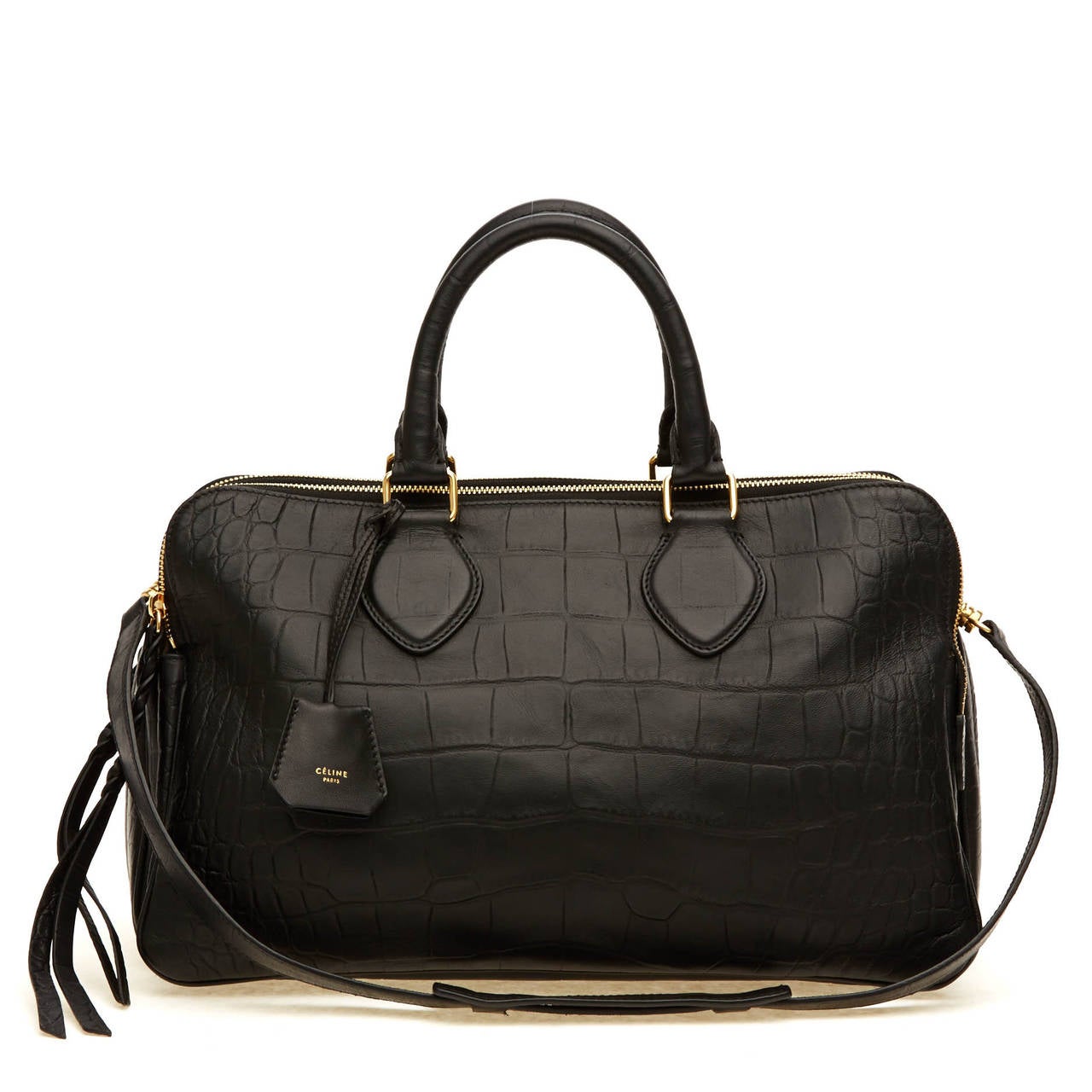 This authentic, striking Celine Triptyque Embossed Crocodile Vertical Bag is featured in black, and accented with gold tone hardware. This beautiful bag has several compartments, and is divided into three main zipped slots. The detachable leather