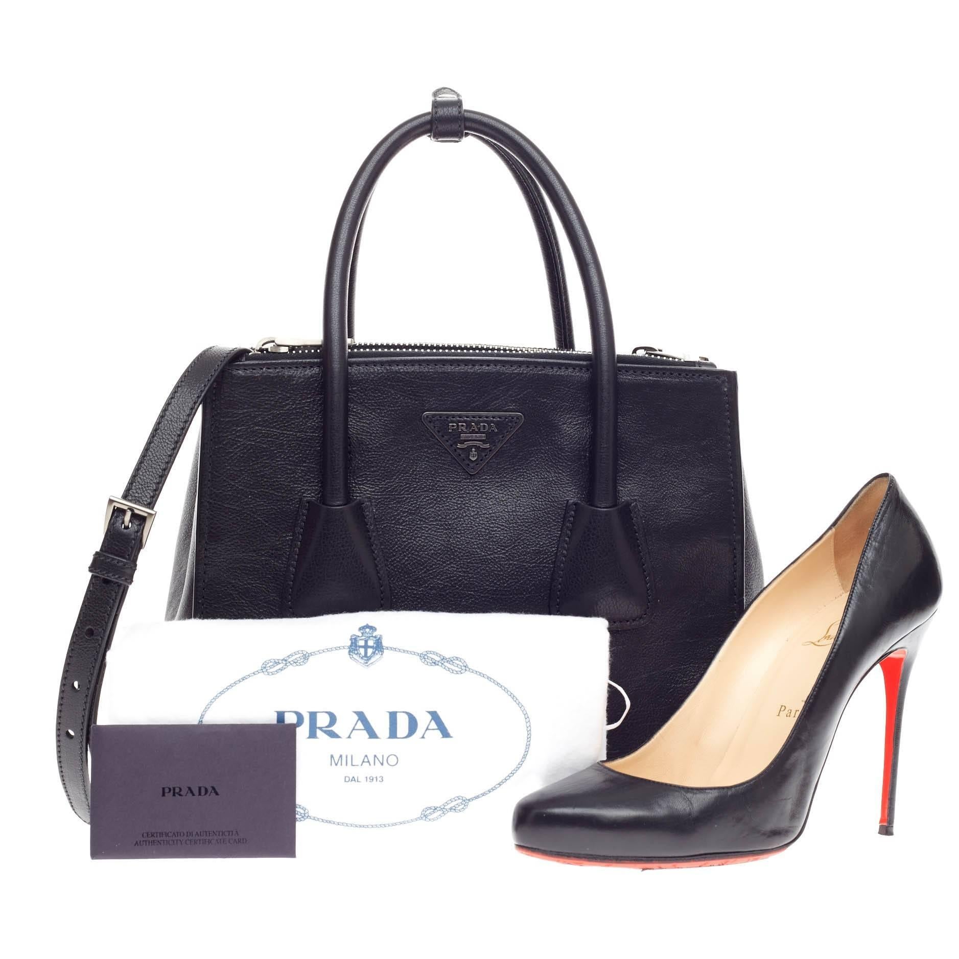 This authentic Prada Twin Pocket Tote Glace Calf Small showcases a sophisticated silhouette balancing modern luxury and style perfect for the on-the-go woman. Crafted from glossy glace calf leather in sleek nero black, this petite, boxy tote