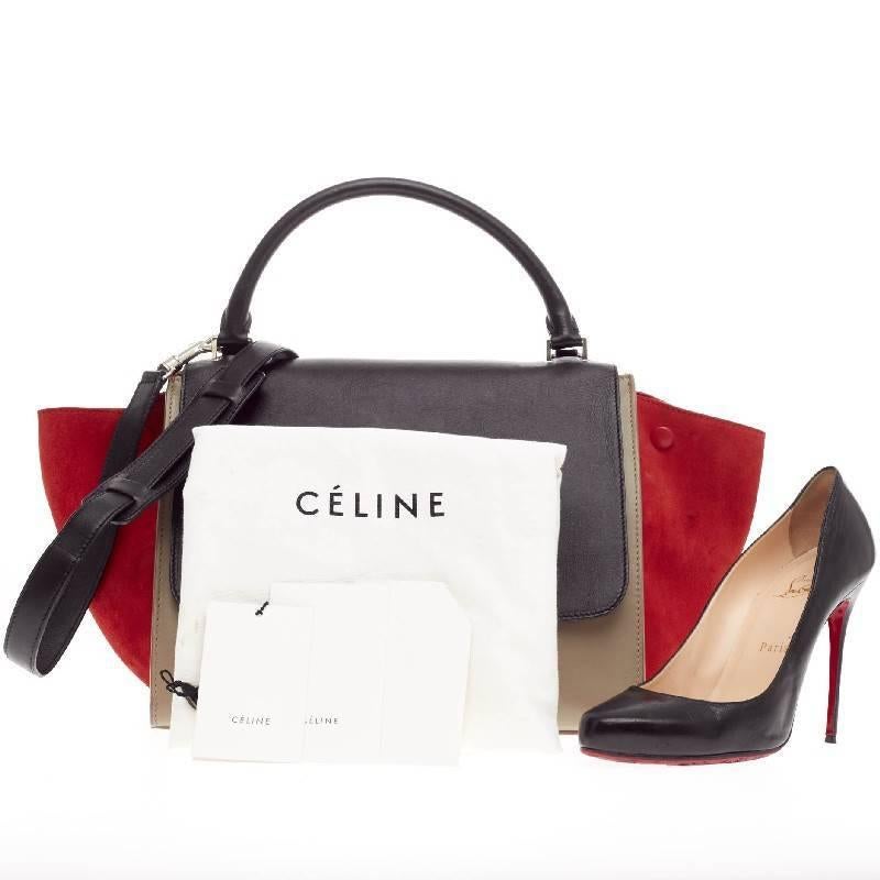 This authentic Celine Trapeze Tricolor Leather and Suede Medium is a modern classic, featuring a taupe and black leather body with stand out burnt orange suede wings. With its neutral yet eye-catching color palette and minimalist design, this bag