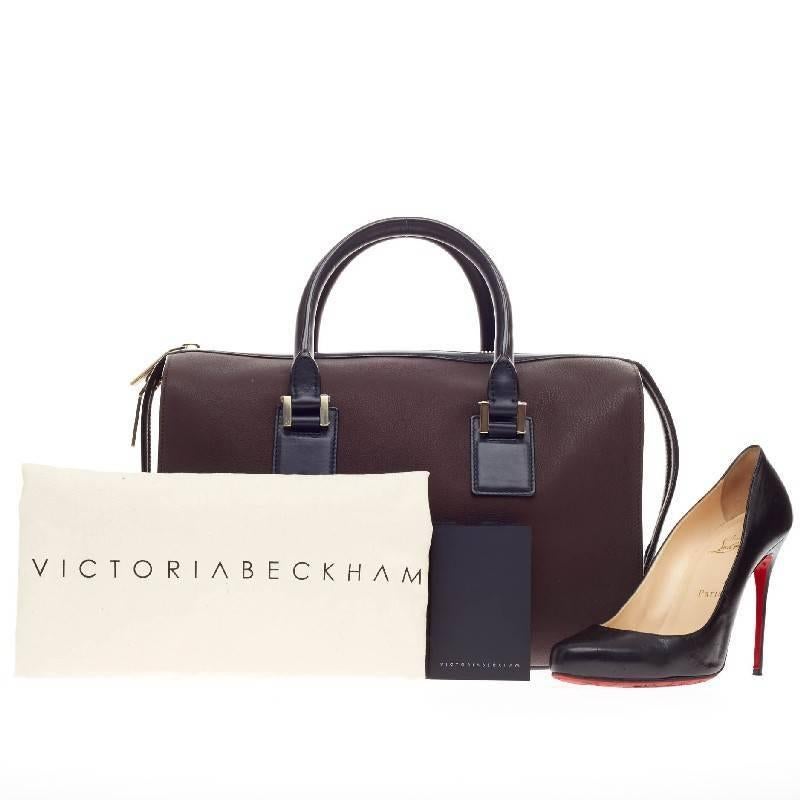This authentic Victoria Beckham East West Victoria Tote Matte Buffalo eponymously named personifies the designer's clean and classic aesthetic. Crafted in rich brown matte buffalo leather with black leather side and base panels and trim, this chic