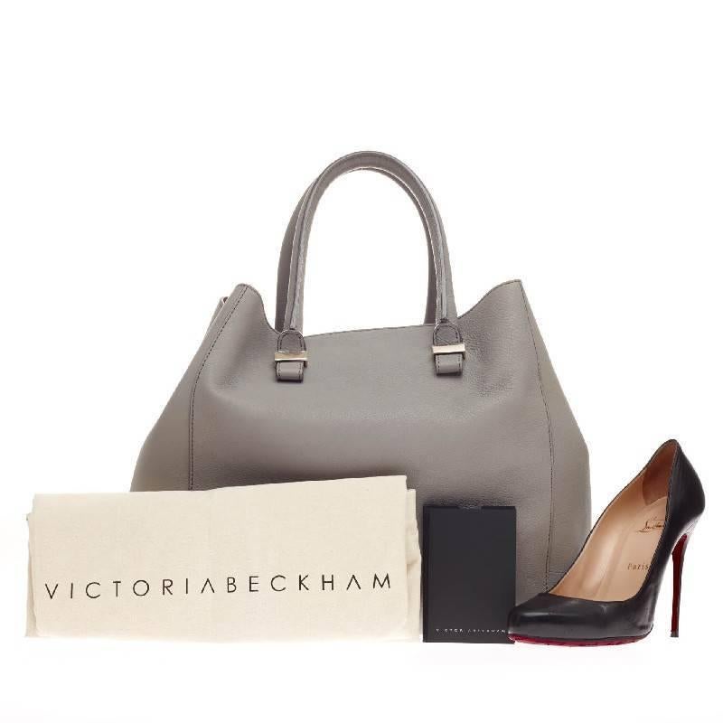 This authentic Victoria Beckham Liberty Tote Leather presents a streamlined, luxe design made for daily excursions. Crafted in beautiful, neutral light gray buffalo leather with pale pink leather trim contrasts, this classic carry-all features