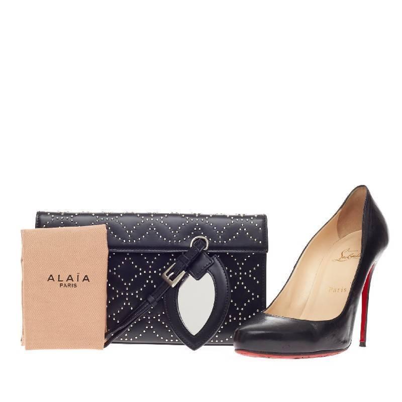 This authentic Alaia Flap Clutch Arabesque Studded Leather showcases Alaia's signature elegant style with an edge. Crafted in sleek black leather with a polished silver geometric stud design, this eye-catching clutch features a hidden magnetic snap