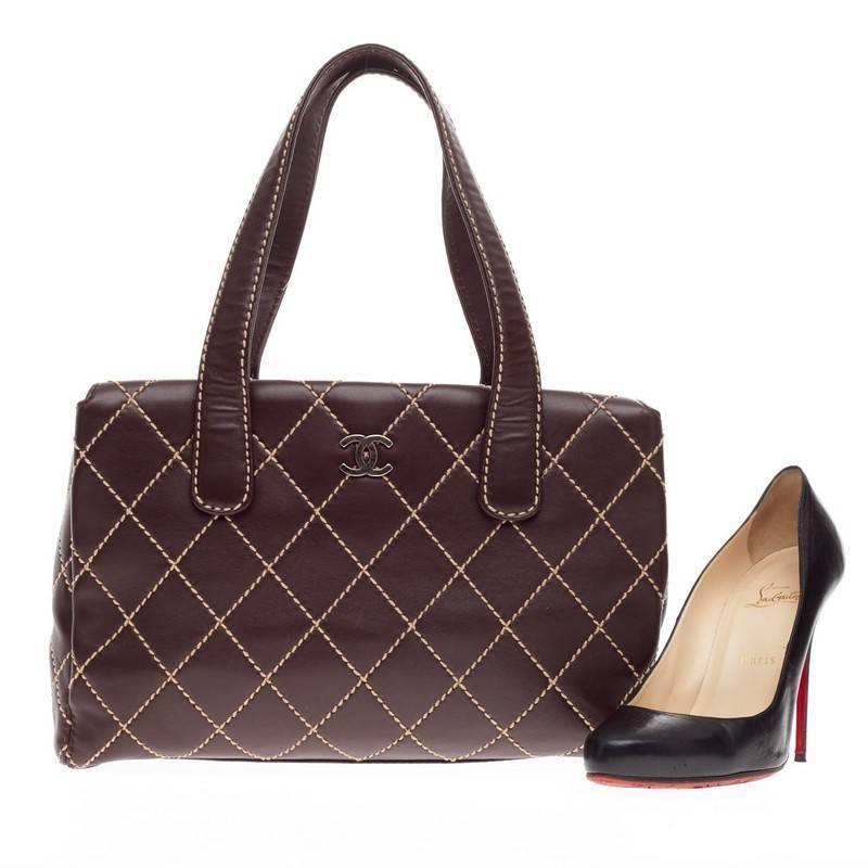 This authentic Chanel Surpique Tote Quilted Leather Large in dark brown features Chanel's distinct diamond quilted contrast stitching accented with iconic CC logo at the front. This functional tote divides into three compartments with magnetic snap
