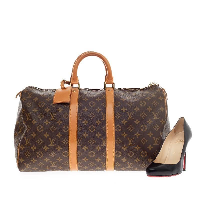 This authentic Louis Vuitton Keepall Monogram Canvas 45 is a glamorous duffle perfect for traveling in style or for a weekend getaway. Crafted in Louis Vuitton's iconic monogram canvas print, this oversized duffle features dual-rolled leather