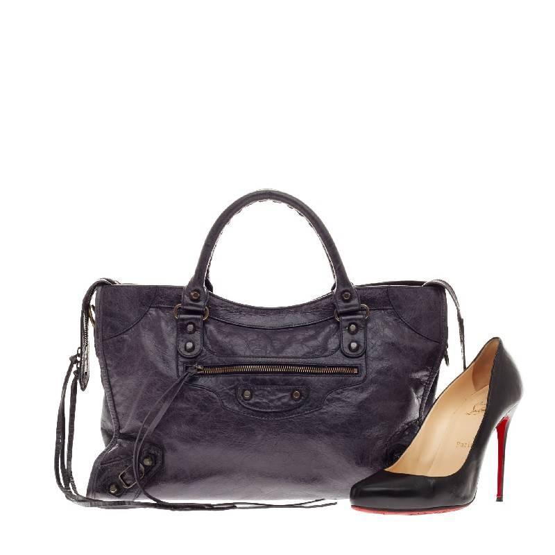 This authentic Balenciaga City Classic Studs Leather Medium in dark purple is for the on-the-go fashionista. Constructed in distressed soft leather, this popular bag features braided woven handle straps, long fringe details, and iconic Balenciaga