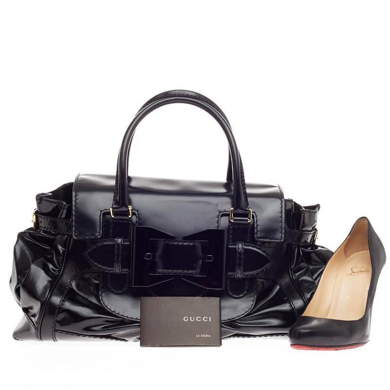 This authentic Gucci Queen Tote Dialux Coated Canvas with Leather Trim Large is ideal for everyday casual looks. Crafted in sturdy black dialux canvas with leather trimmings, this tote features a chic frontal metal bow design, pleated silhouette,