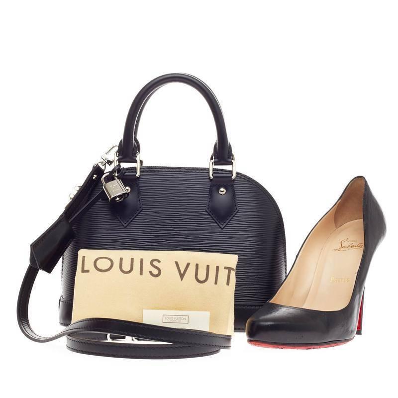 This authentic Louis Vuitton Alma Epi Leather BB in sleek black showcases a classic style in a playful, miniature version. Constructed with Louis Vuitton's signature sturdy epi leather,  this petite dome-like bag features a sturdy base, dual-rolled