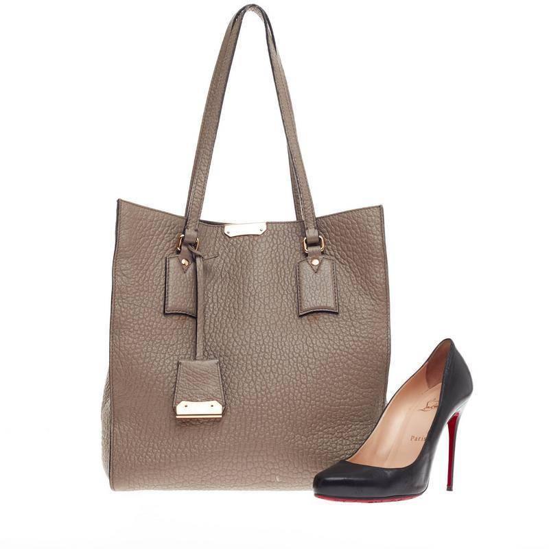 This authentic Burberry Woodbury Tote Heritage Grain Leather Medium in clean and modern design is ideal for everyday use. Crafted in taupe pebbled leather, this luxurious, easy-chic tote features tall dual-flat handles, detachable leather tag,