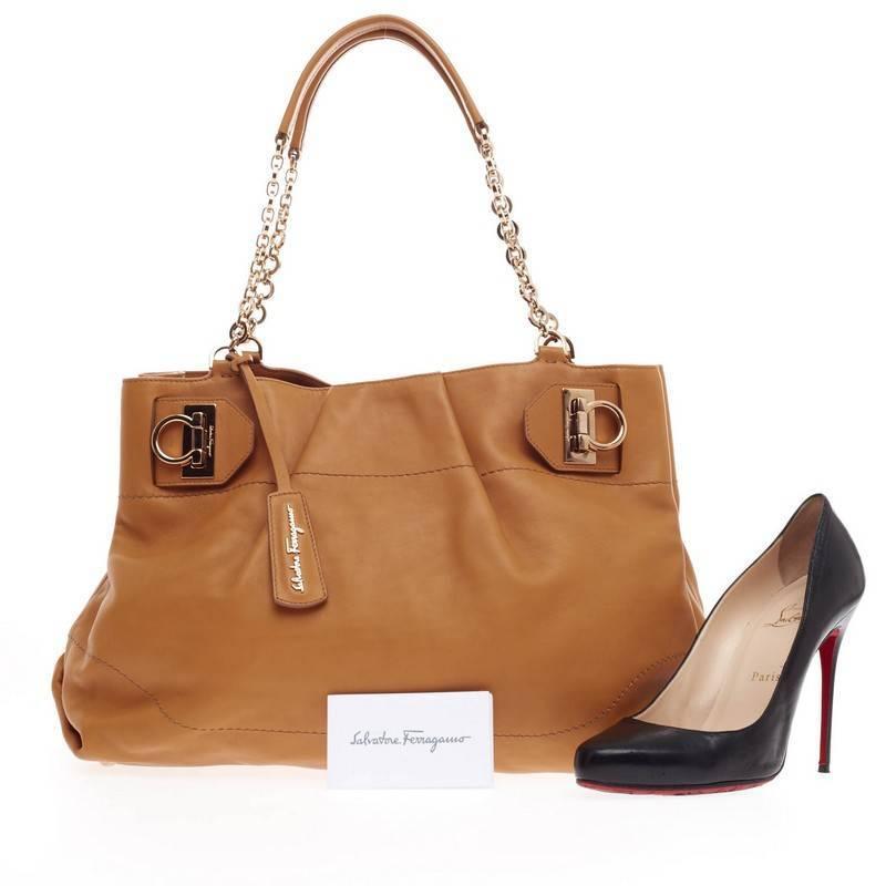 This authentic Salvatore Ferragamo W Chain Tote Leather Large showcased in the brand's Fall/Winter 2013 Collection is beautifully crafted in camel calfskin leather and accented with signature polished gold Gancini clasps for a secure closure. Its