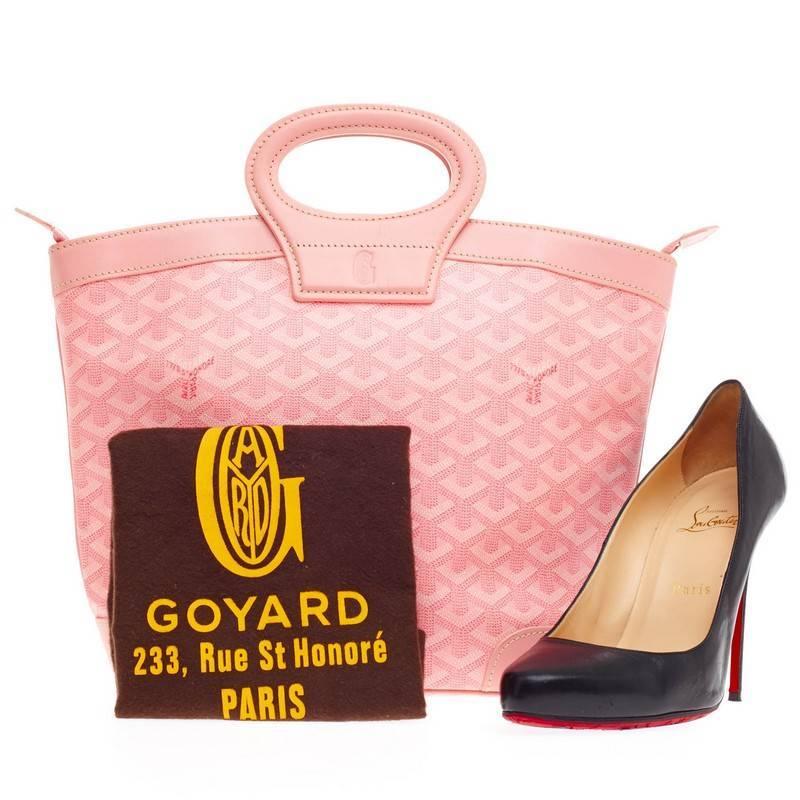 This authentic Goyard Beluga Canvas PM released first in late 2009 is crafted from the popular and sought-after pink and white Goyard chevron canvas. This fan-shaped tote features leather top ring handles, a structured base with protective studs,