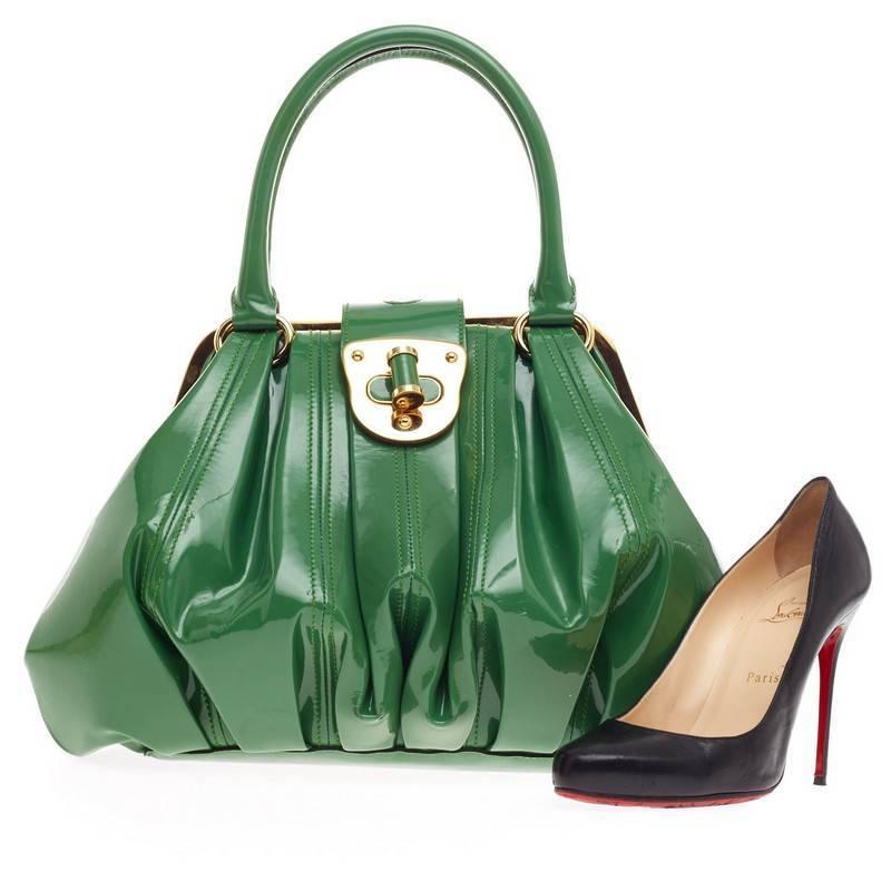 This authentic Alexander McQueen Elvie Frame Bag Patent is perfect for all seasons. Crafted in beautiful grass green patent leather, this elegant yet chic frame bag features dual-rolled handles, pleated detailing and gold-tone hardware accents. Its