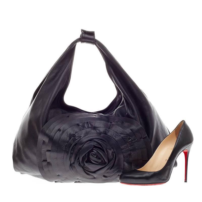 This authentic Valentino Petale Hobo Leather in Large stylishly combines a casual silhouette with elegant motifs characteristic of Valentino's designs. Crafted from supple black leather, this bag features an oversized leather flower design, dual