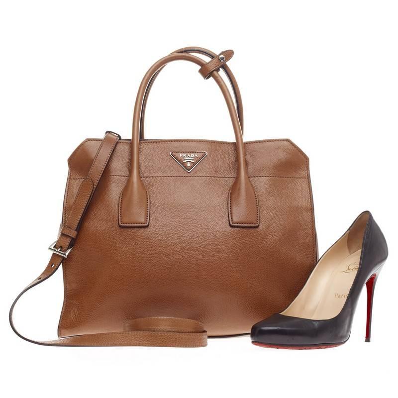 This authentic Prada Twin Tote Cervo Leather showcases a modern silhouette perfect for today's woman. Crafted from classic, durable tan cervo leather, this stylish and functional boxy tote features tall dual-rolled handles, raised Prada logo at the