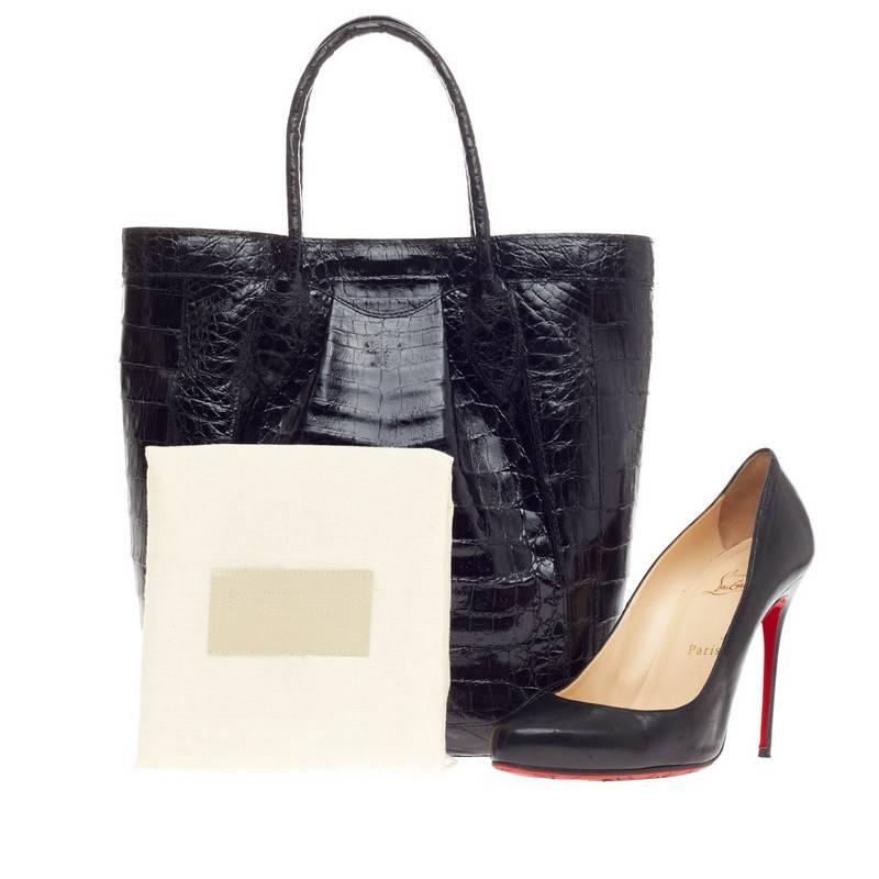 This authentic Nancy Gonzalez Tote Crocodile Tall showcases the brand's attention to high craftsmanship and classic design. Crafted in genuine black crocodile skin with a shiny finish, this luxurious tote features a simple silhouette, and tall