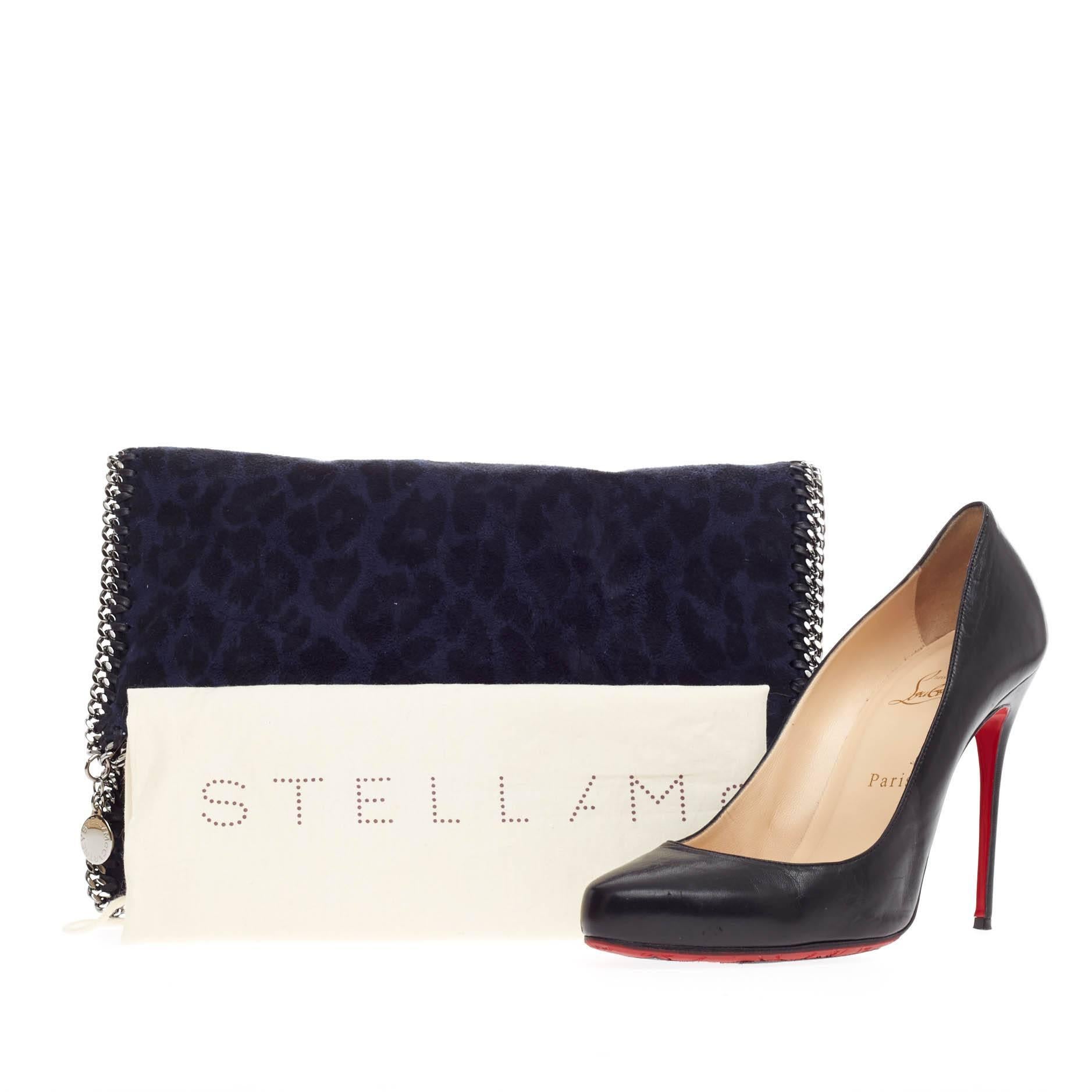 This authentic Stella McCartney Falabella Fold Over Clutch Leopard Print Faux Suede is perfectly textured with classic black and blue faux leopard print suede that is chic with a twist. This fold over clutch features silver chain link handles and